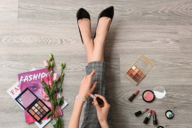 Makyaj sanatçısı ahşap zemine ruj sürüyor.