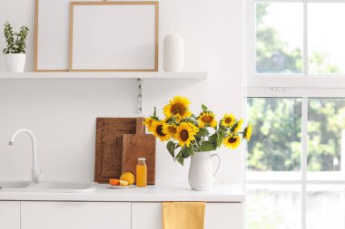 Ayçiçekli vazo açık mutfakta tezgahta.