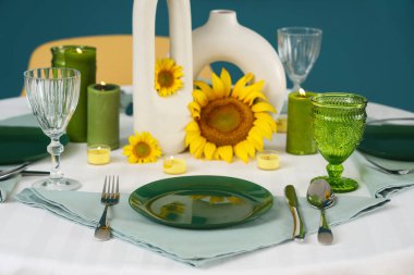 Masa ayçiçekli, mavi duvarlı.