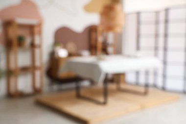 Kanepesi, rafları ve katlanan ekranı olan modern spa salonunun bulanık görüntüsü