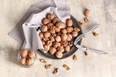 Gri arka planda lezzetli cevizli tabak ve kavanoz.