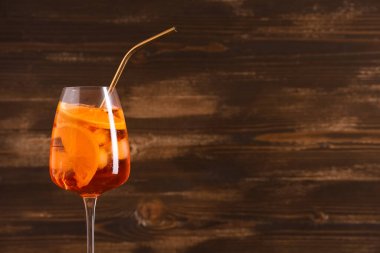 Ahşap arka planda bir bardak Aperol Spretz kokteyli.