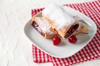 Beyaz arka planda vişneli turta tabağı.