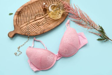 Renkli arka planda şık kadın sütyeni, aksesuar ve çiçek kompozisyonu