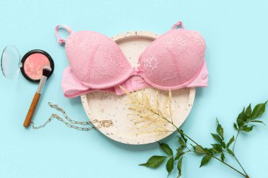 Renkli arka planda şık kadın sütyeni, aksesuar ve çiçek kompozisyonu