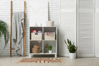 Çekmeceleri, merdiveni ve katlanmış ekranı olan odanın içi.