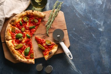 Lezzetli pizzalı kompozisyon ve mavi arka planda kesici.