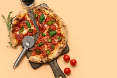 Lezzetli pizzalı kompozisyon ve bej arka planda kesici.