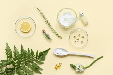 Sarı arka planda doğal kozmetik ürünleri hazırlamak için gerekli malzemelerle dolu bir şişe yağ ve petri.
