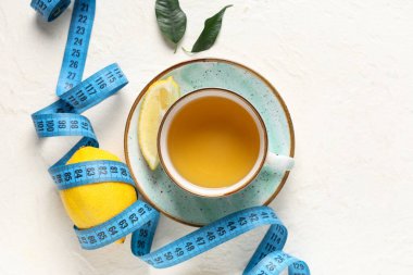 Bir fincan diyet çay, taze limon ve arka planda şerit. Kilo verme konsepti