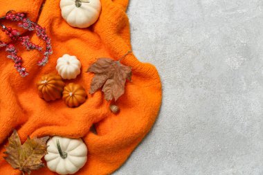 Şık, sıcak süveter, sonbahar mumları ve arkaplanda balkabakları olan kompozisyon