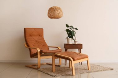 Oturma odasının içinde hasır lamba, koltuk ve kanepe var.