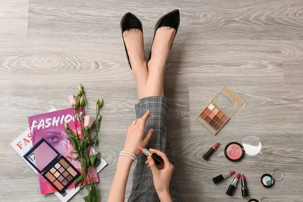 Makyaj sanatçısı ahşap zemine ruj sürüyor.