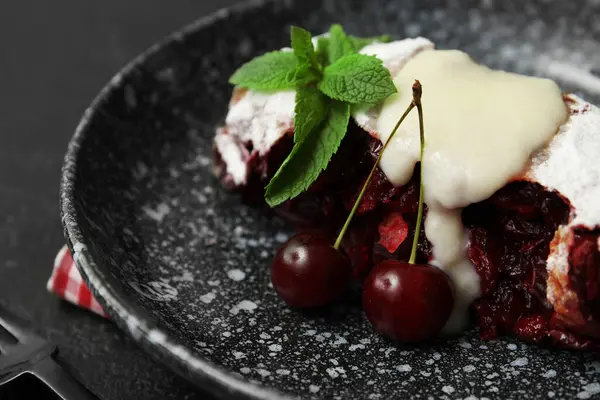 Siyah arka planda lezzetli vişneli turta ile kaplanmış, yakın plan.