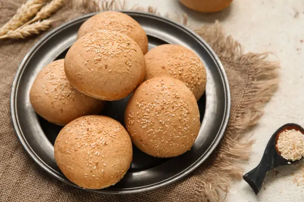 Susamlı taze çörekler ve beyaz arka planda buğday.