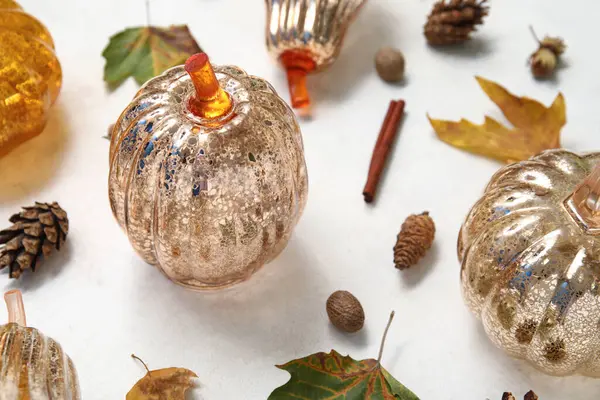 Sonbahar yapraklı dekoratif balkabakları ve beyaz arka planda meşe palamudu, yakın plan