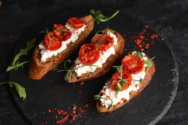 Siyah arkaplanlı lezzetli domates bruschetta.