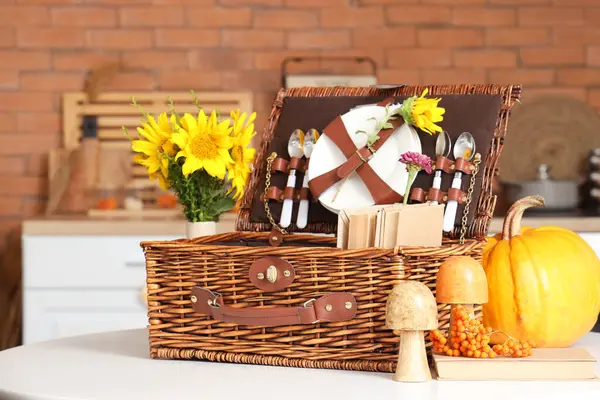 Mutfaktaki yemek masasında sonbahar dekoru ve ayçiçekli piknik sepeti.