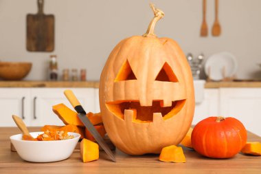 Cadılar Bayramı balkabağını bıçakla oydum ve tezgahın üzerine bir kase tohum koydum.