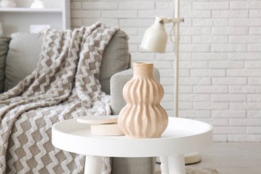 Oturma odasındaki kanepenin yanında vazo olan kahve masası. Yakın çekim.