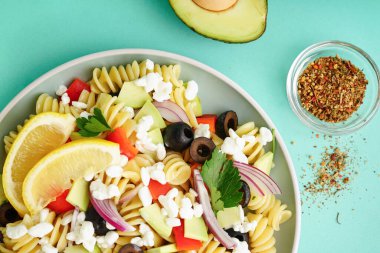 Turkuaz arka planda geleneksel makarna salatası ile tabak