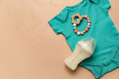 Bebek için süt, beden giysisi ve renk arka planında ip.