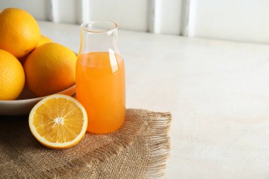 Bir şişe taze portakal suyu ve beyaz arka planda meyveler.