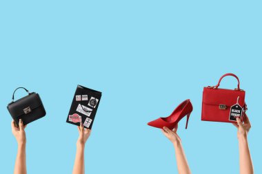 Alışveriş çantalı, aksesuarlı ve mavi arka planda etiketli kadın elleri. Kara Cuma indirimi