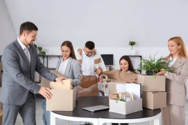 Bir grup iş adamı taşınma günü ofiste eşyalarını topluyor.