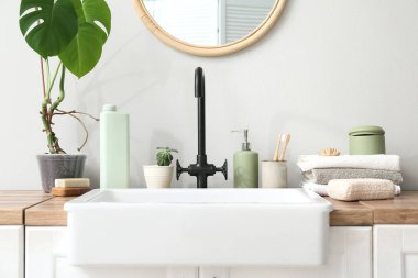 Banyodaki ışık duvarının yanında farklı banyo aksesuarları.