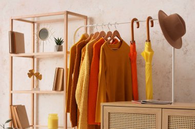 Soyunma odasında kazak, şemsiye ve şapkayla dizilin.