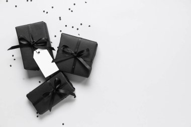 Gri arka planda siyah hediye kutuları ve konfeti