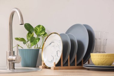 Mutfakta lavabonun yanında temiz tabakları olan bir tutucu.