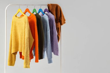 Gri arkaplanda renkli süveter rafı