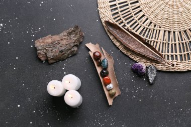 Koyu arkaplanda çakra taşları, tütsü ve mumlar.