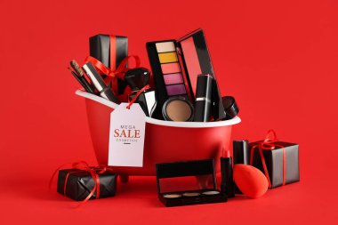 Dekoratif kozmetik ürünleri, hediye kutuları ve kırmızı arka planda satış etiketi olan küçük küvet.