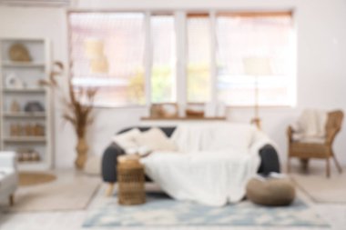 Oturma odasının içinde kanepe, raf ünitesi ve hasır sandalye, bulanık görüş.