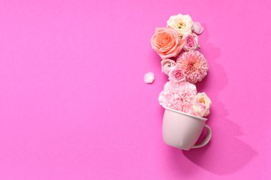 Fincanlı kompozisyon ve pembe arka planda güzel çiçekler.