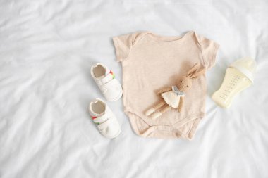 Bebek sütü formülü, oyuncak tavşan, tulum ve patik.