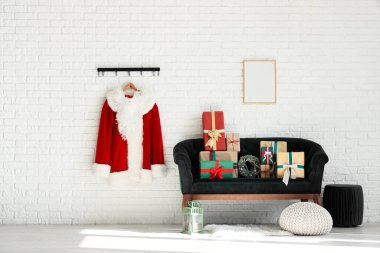 Noel Baba kostümü, kanepe ve Noel hediyeleriyle oturma odasının içinde.