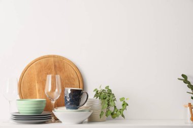 Masada beyaz arka planda temiz bulaşık ve bitki var. Yakın çekim.