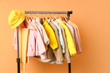 Süslü çocuk kıyafetleri ve turuncu arka planda aksesuarlarla doldur.