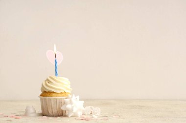 Beyaz arka planda yanan mum ve konfeti olan tatlı doğum günü keki.