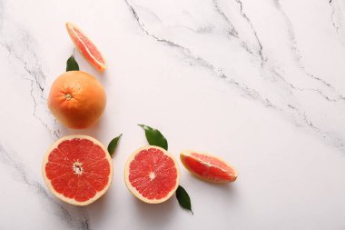 Taze greyfurtlar ve beyaz arka planda yapraklar