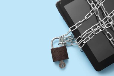 Renk arkaplanına asma kilit ve zincir bağlanmış modern tablet bilgisayarı