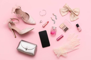 Yüksek topuklu kompozisyon, kozmetik ürünler ve pembe arka planda aksesuarlar. Üst görünüm