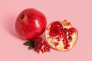 Pembe arka planda taze nar ve yapraklar.