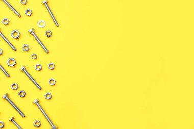 Sarı arka planda cıvatalar ve krom fındıklar