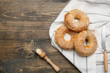 Tahta arka planda susam tohumlu lezzetli simitler.
