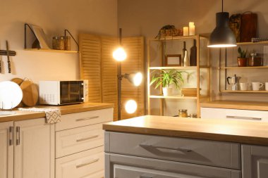 Mutfağın içinde tezgahlar, raflar ve gece lambaları var.